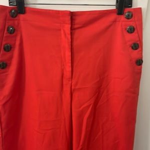 Zip front, 2 pockets in the front with 4 buttons accent, 2 faux rear pockets.